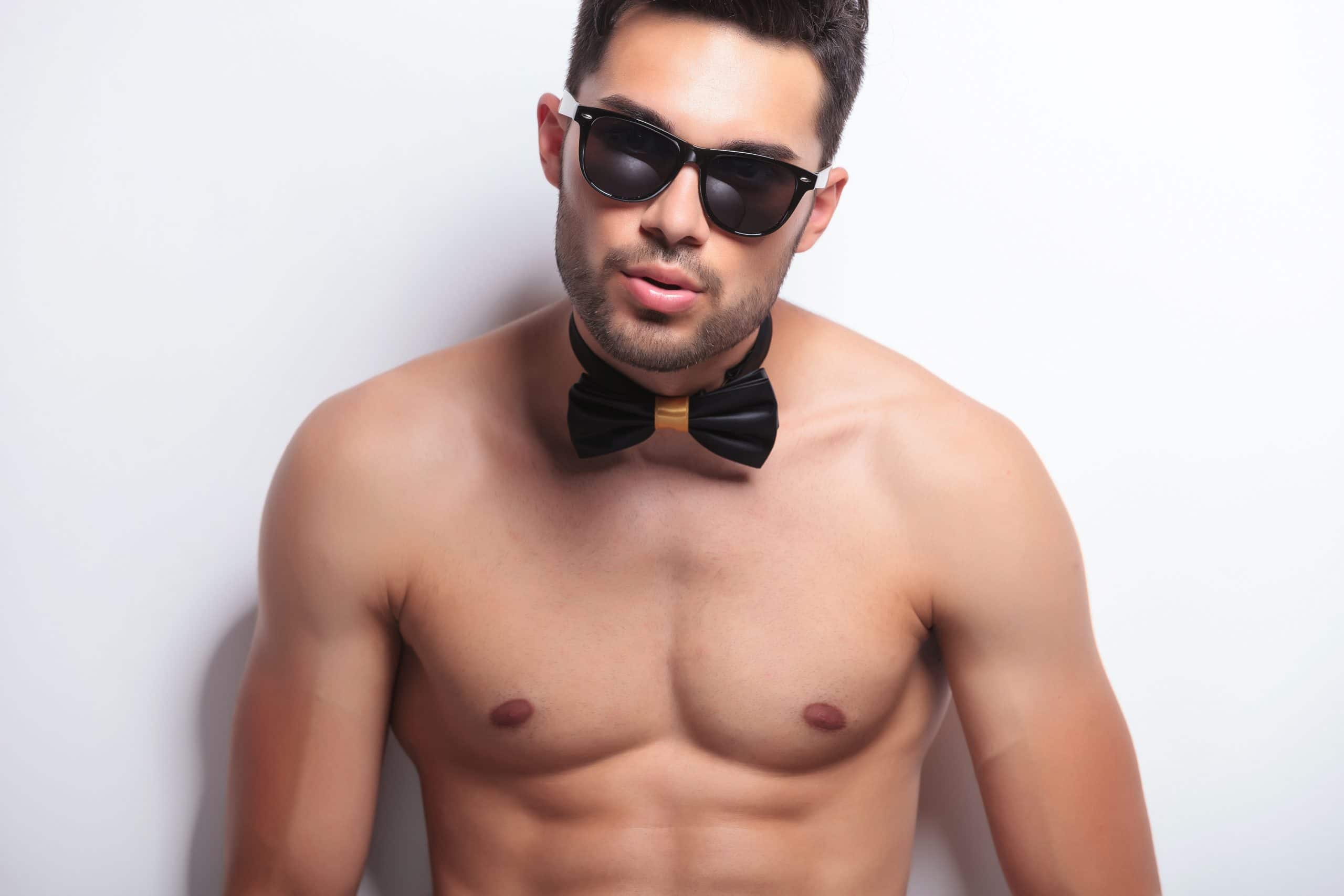 Male stripper with sunglasses and bow tie posing